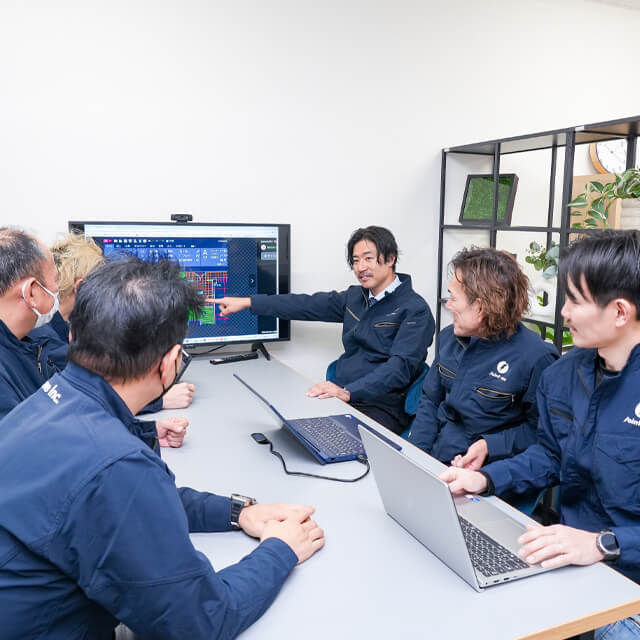 社内で施工の打ち合わせをする代表とチーム